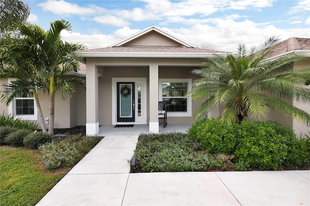 view of exterior entry featuring covered porch