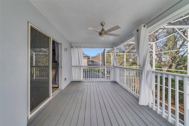 unfurnished sunroom featuring ceiling fan