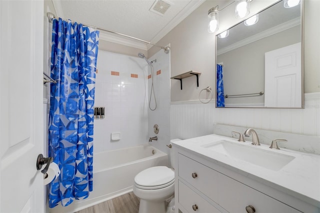 full bathroom with toilet, a wainscoted wall, visible vents, shower / bath combo with shower curtain, and crown molding