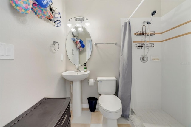 bathroom featuring tiled shower, a sink, and toilet