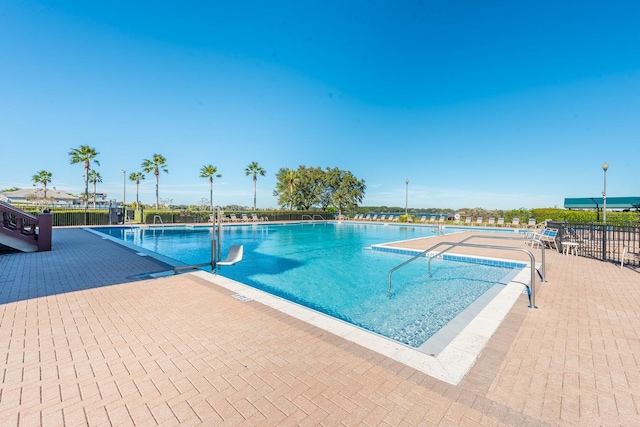 pool with fence and a patio