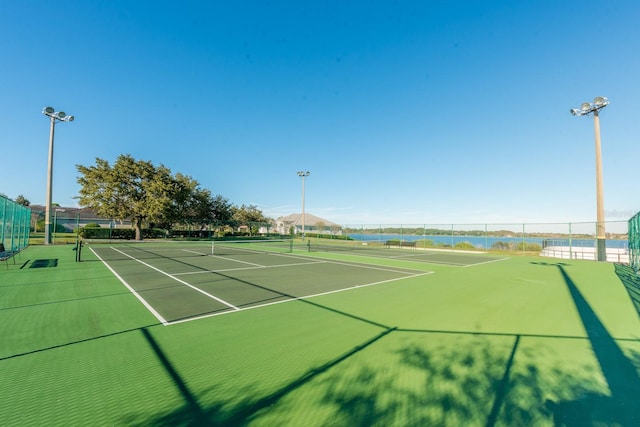 view of tennis court featuring community basketball court and fence