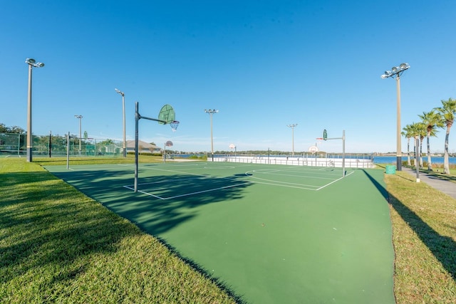 view of basketball court featuring community basketball court, fence, and a lawn