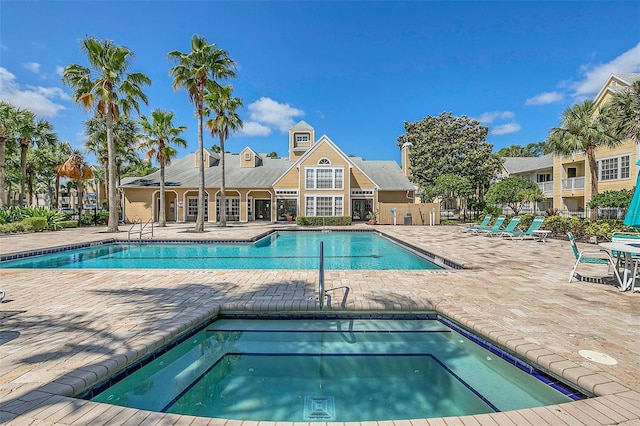 view of swimming pool featuring a patio and a community hot tub