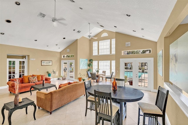 tiled living room with high vaulted ceiling, french doors, and ceiling fan