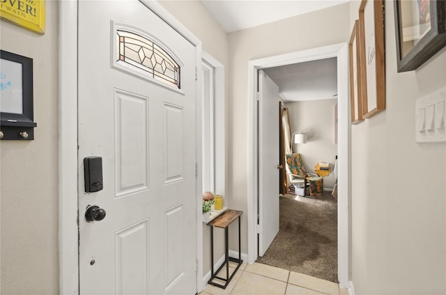 entryway featuring light colored carpet, baseboards, and light tile patterned floors