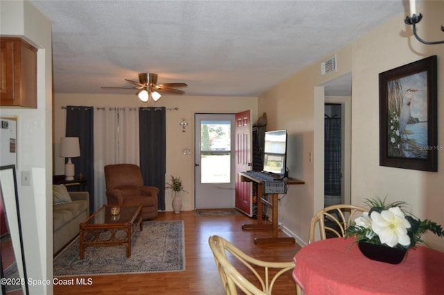 living room featuring dark wood-type flooring and ceiling fan