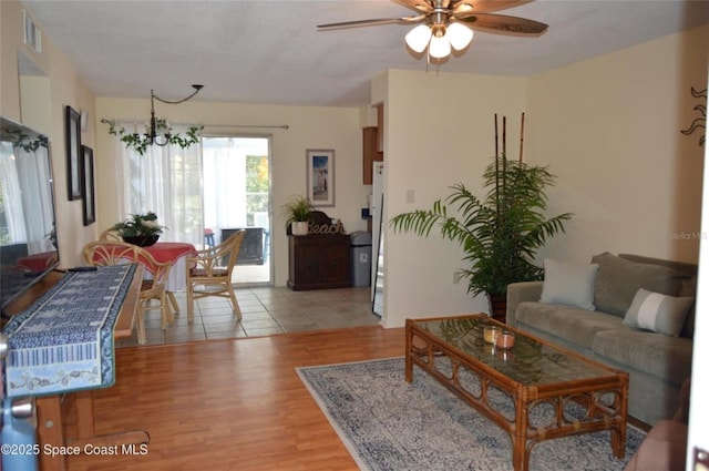 living room featuring ceiling fan and light wood-type flooring