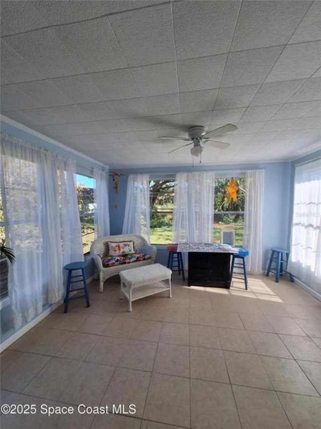 unfurnished sunroom with ceiling fan