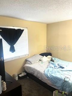 4944 Sanoma Vlg Unit D, Orlando, FL 32808 - bedroom featuring a textured ceiling