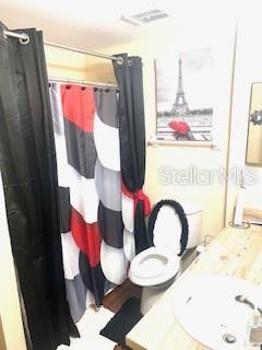 4944 Sanoma Vlg Unit D, Orlando, FL 32808 - full bathroom featuring a sink, wood finished floors, and curtained shower