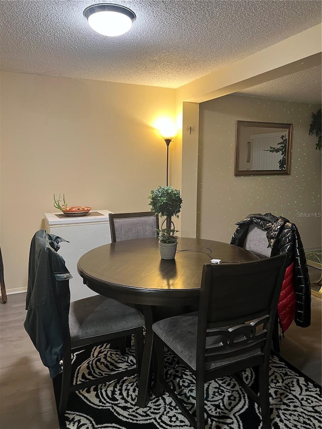 4944 Sanoma Vlg Unit D, Orlando, FL 32808 - dining space with baseboards, a textured ceiling, and wood finished floors