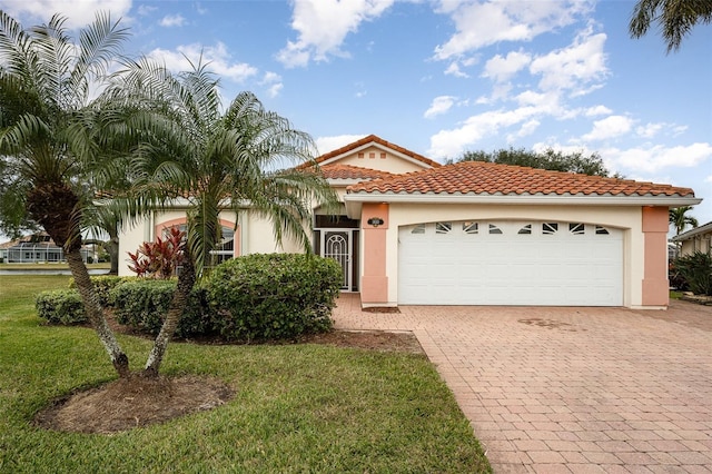 mediterranean / spanish house with a garage and a front yard