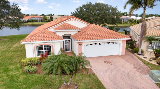 mediterranean / spanish house with a water view, a garage, and a front lawn