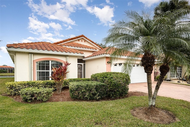 mediterranean / spanish house featuring a garage and a front lawn