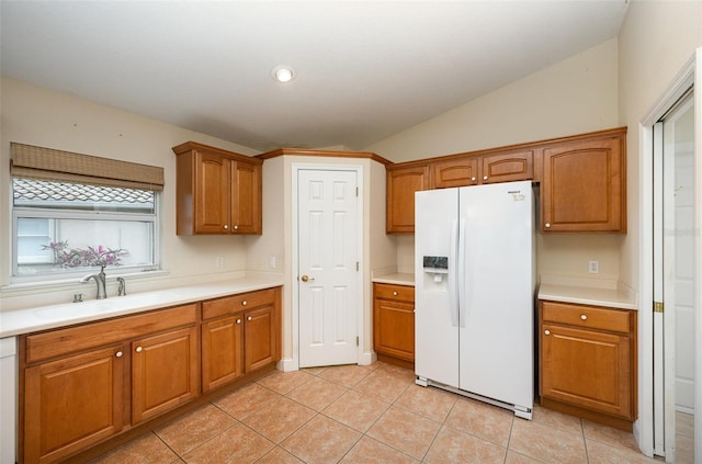 kitchen with light tile patterned flooring, lofted ceiling, sink, and white appliances