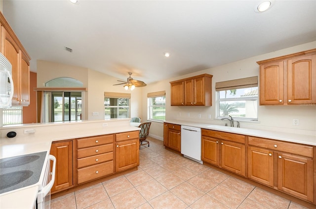 kitchen with light tile patterned flooring, sink, vaulted ceiling, kitchen peninsula, and white appliances