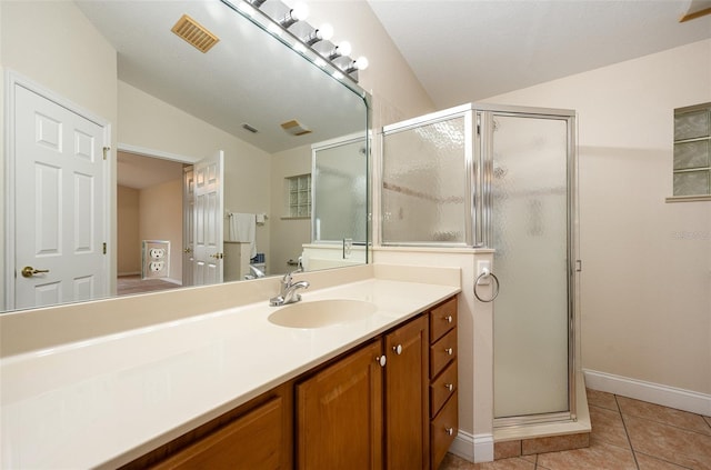 bathroom with tile patterned flooring, vanity, lofted ceiling, and a shower with door