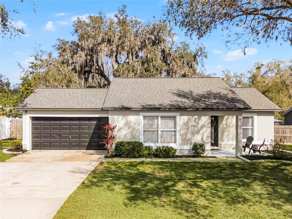 single story home with a garage and a front lawn