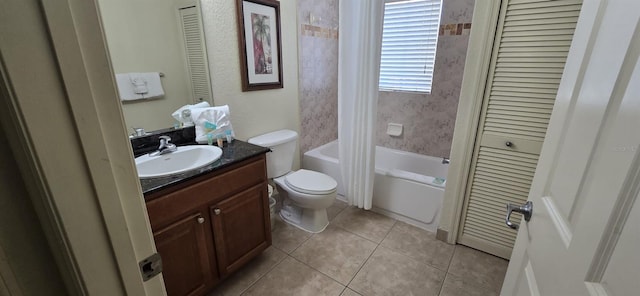 full bathroom with tile patterned flooring, vanity, tiled shower / bath, and toilet