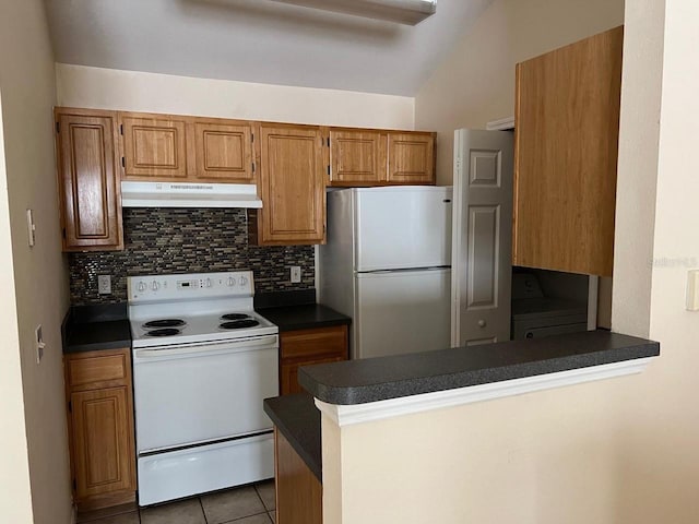 kitchen featuring kitchen peninsula, stainless steel fridge, tasteful backsplash, and electric range