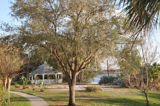 view of property's community with a water view, a lawn, and a gazebo