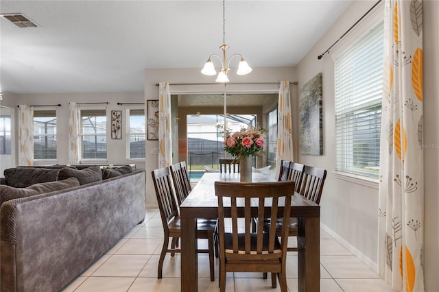 dining area with light tile patterned floors and an inviting chandelier