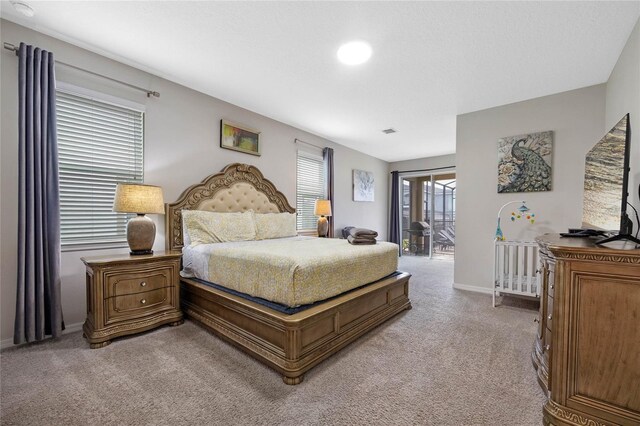 bedroom with access to outside and light colored carpet