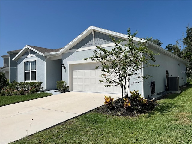 view of front of house with driveway, a garage, a front yard, central AC, and stucco siding