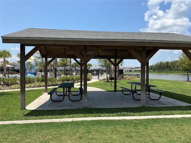 view of home's community with a water view, a gazebo, fence, and a yard