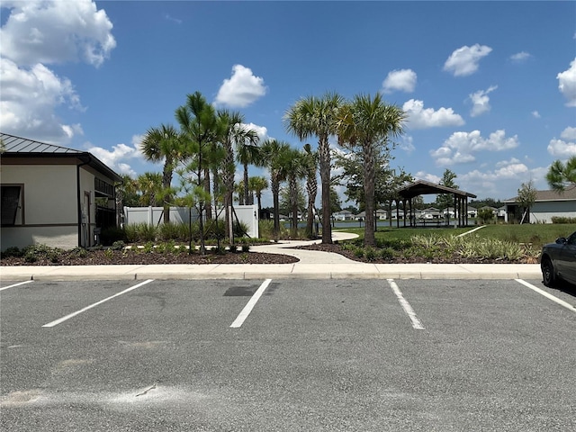 uncovered parking lot featuring a gazebo and fence