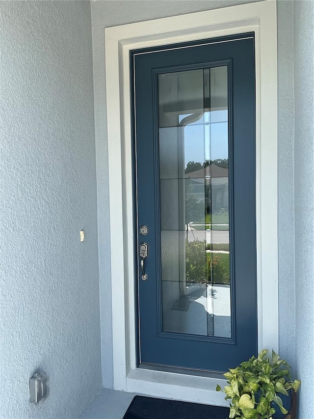 property entrance with stucco siding