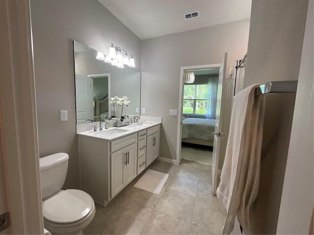 ensuite bathroom featuring connected bathroom, toilet, a sink, visible vents, and double vanity