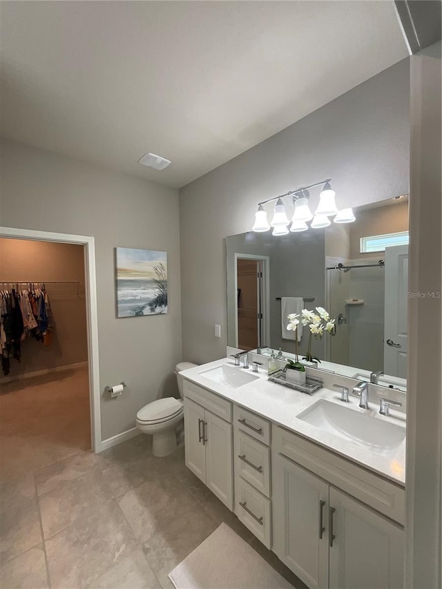 full bath featuring double vanity, a stall shower, a sink, and a walk in closet