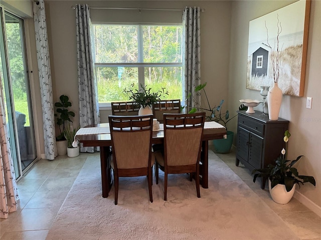 dining area featuring a wealth of natural light, baseboards, and light tile patterned floors