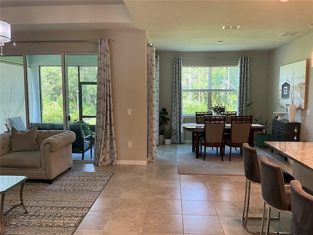living area with visible vents, baseboards, and light tile patterned flooring