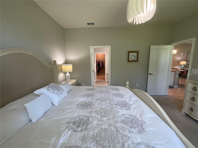 carpeted bedroom with visible vents and a spacious closet