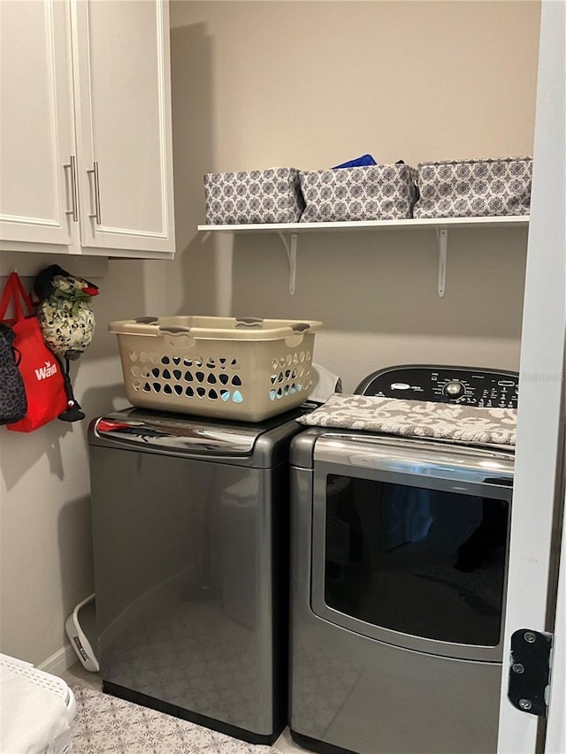 laundry area featuring cabinet space, baseboards, and washing machine and clothes dryer