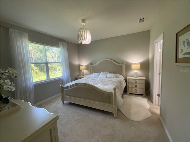 bedroom featuring visible vents, light carpet, and baseboards