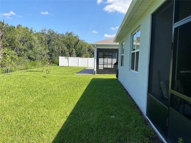 view of yard with a sunroom and fence
