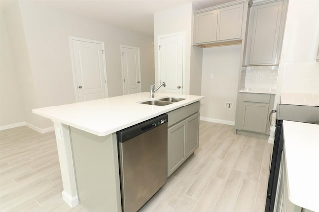 kitchen featuring gray cabinets, dishwasher, sink, and an island with sink