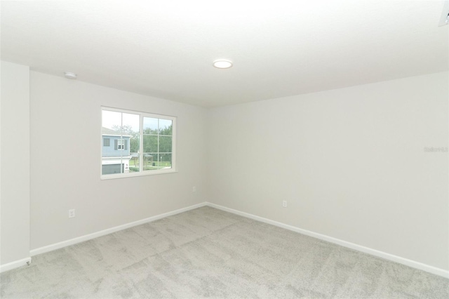 unfurnished room featuring light carpet