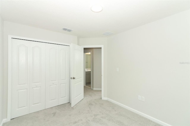 unfurnished bedroom with a closet and light carpet