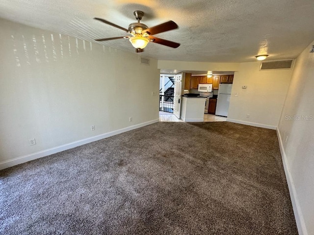 unfurnished living room with ceiling fan, light colored carpet, and a textured ceiling