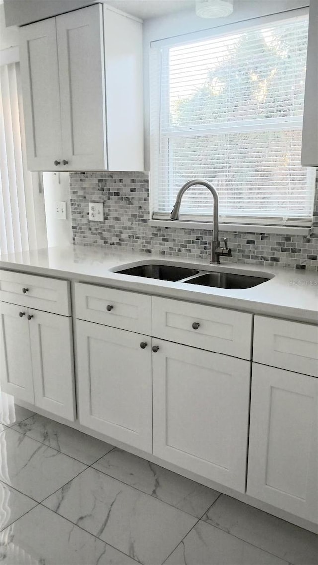 kitchen featuring white cabinetry, sink, and decorative backsplash