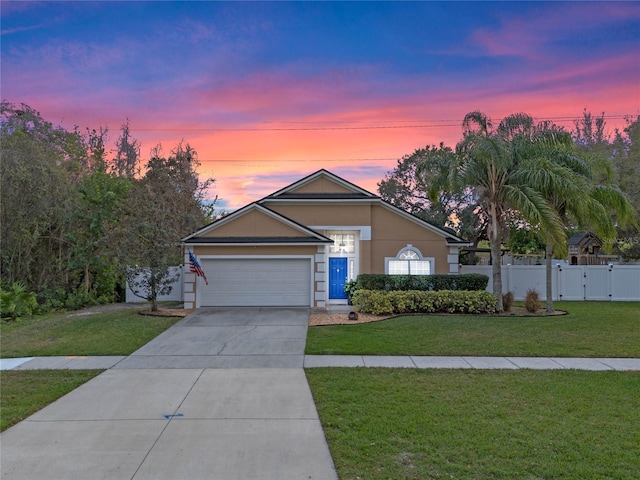 ranch-style house with a yard and a garage