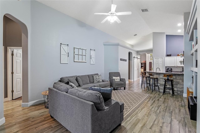 living room featuring high vaulted ceiling, hardwood / wood-style floors, and ceiling fan