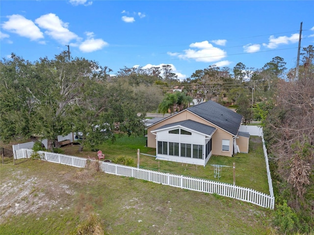 rear view of property with a lawn and a sunroom