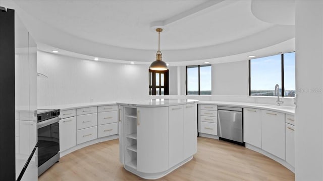 kitchen featuring white cabinetry, hanging light fixtures, light hardwood / wood-style flooring, and appliances with stainless steel finishes