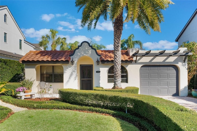 mediterranean / spanish house featuring a garage and a front yard